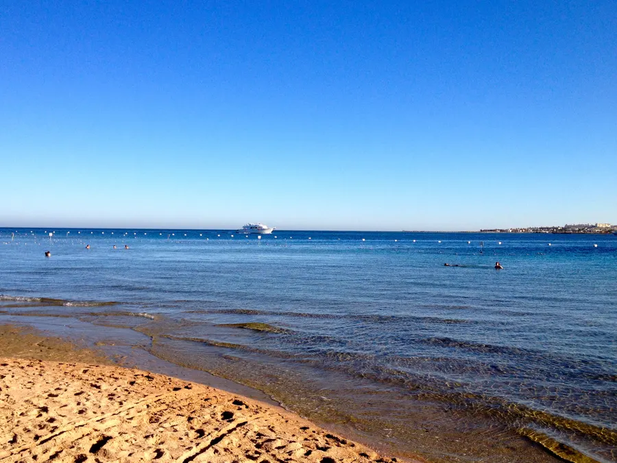 Calm blue sea meeting a clean sandy shore